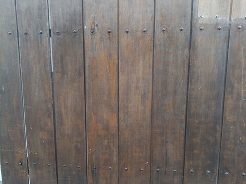 Rustic Vertical Wood Plank Texture. Dark Brown Weathered Timber Fence Background with Rusty Nails. Natural Wooden Surface for Industrial Design and Architectural Mockups.