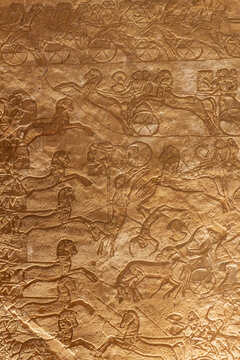Ancient egyptian relief carving featuring war chariots, horses, and soldiers engaged in a historical battle at abu simbel, aswan