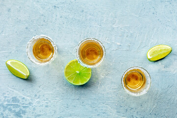 Tequila shots with salted rims and lime slices, shot from the top © CookShootsFood