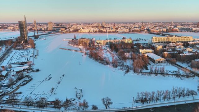 Riga, Latvia - Snow covered Duagava River and Vansu Bridge, aerial view at sunset