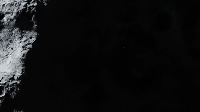 A gray asteroid tumbles through deep empty space in dramatic slow motion, its rocky cratered surface rendered in three-dimensional detail.