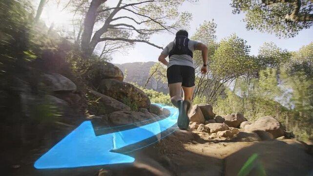 Running male in hydration vest and black shorts ascending rocky trail, following blue arrow