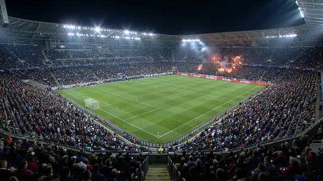 Enthusiastic fans create vibrant scene with flares and shouts