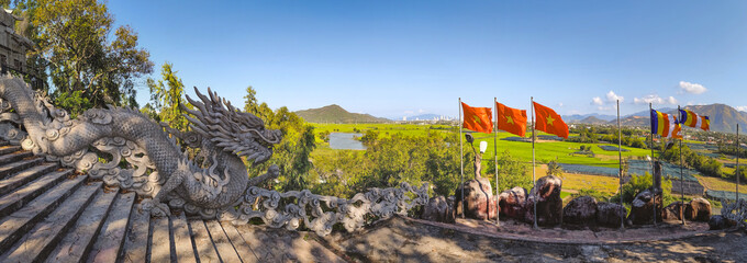 View of Nha Trang from Tong Lam Son Temple with flags and rice fields Vietnam © Olga Khoroshunova