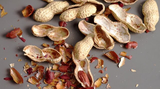 Close up of peanut shells and fragments scattered on kitchen table after eating. Snack leftovers. Natural food waste