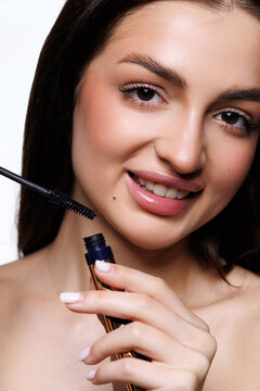 Long lashes make everything better. Portrait of a beautiful young woman applying mascara against a white background.