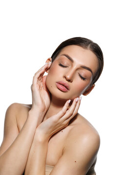 Natural beauty concept. Young woman with glowing clean skin smiling at camera on white studio background