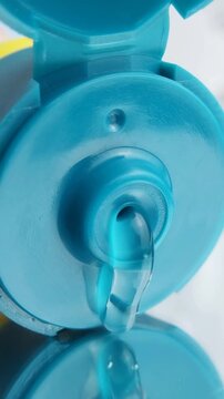 Close up of transparent cream slowly dispensing over glass reflection, moisturizing skincare product with smooth glossy texture.