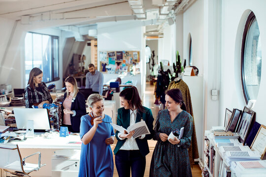 Fashion design team reviewing samples in creative studio