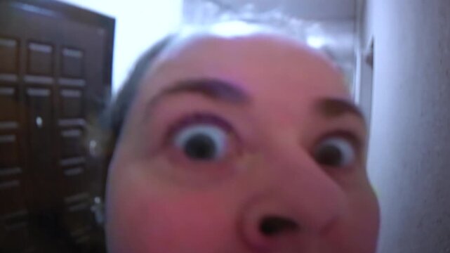 A woman standing in front of a security camera in a door peephole.