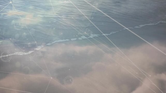 Starting over clouds camera tilting down toward sea under digital grid showing data reaching shore