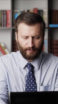 Vertical view upset disgruntled man at workplace typing on laptop keyboard and grumbling, cursing. Manager syndrome, burnout, stress, business problems, negative reaction, frustrated employee concept