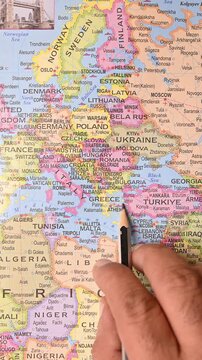 Male Hand Pointing Greece on Map with Pencil &ndash; Top View, Vertical Footage