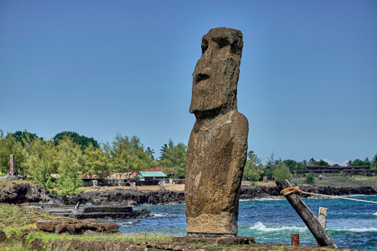 Beeindruckende Moai-Statue auf der Osterinsel vor blauem Meer und K&uuml;stenlandschaft