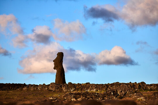 Silhouette einer Moai-Statue auf der Osterinsel vor dramatischem Abendhimmel.