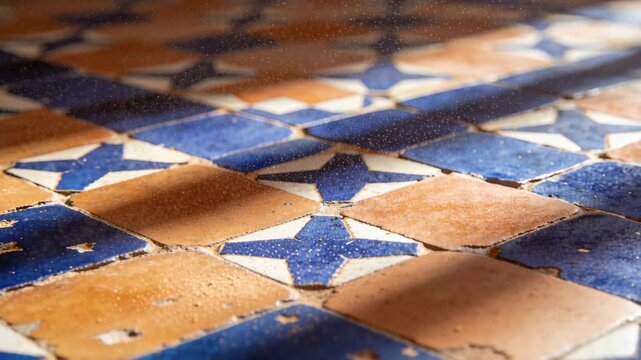 Shifting light from slats casting diagonal shadows across blue-star tiles, chips and dust drifting