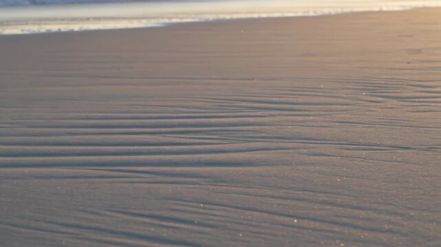 Slow camera panning revealing rippled wet sand texture for designers and marketers' backgrounds