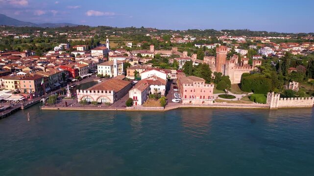 Italy Lake Garda Authentic Lazise town Aerial 4K Video Drone Side Tracking Flight Along Waterfront Promenade with Colorful Houses and Medieval Scaliger Castle Fortress, Scenic Travel Destination