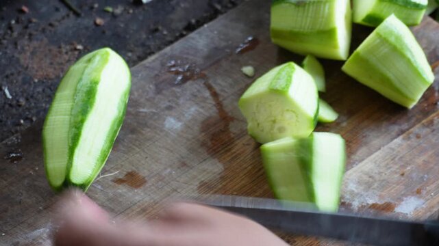 Slicing pointed gourd parwal fresh green vegetable preparation in kitchen