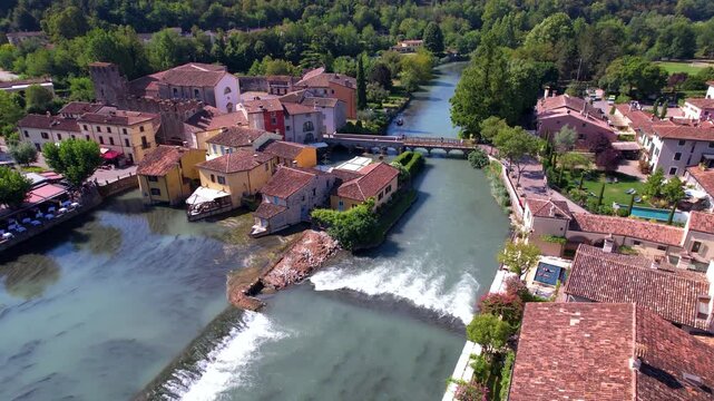 Italy Borghetto sul Mincio Aerial 4K Video Vertical Drone Lift Above Medieval Village Colorful Houses on Mincio River Waterfalls Near Valeggio and Lake Garda Scenic Travel. I Borghi pi&ugrave; belli d'Italia