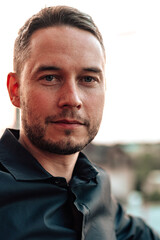 Fototapeta premium Man sits in outdoor setting with soft lighting during sunset in a casual moment