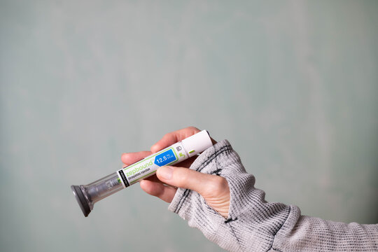 Limestone, TN, USA-March 11, 2026:  Female hand holding a Zepbound injector pen.