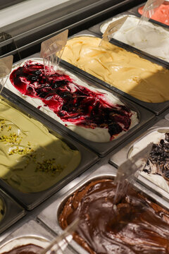 Vaschette di gelato artigianale di vari gusti pronte in una vetrina di una gelateria artigianale