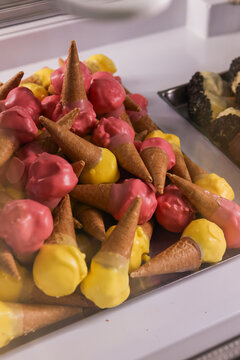 Mini coni gelato al limone e alla fragola creati da una gelateria artigianale e pronti per essere venduti