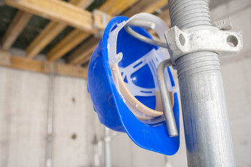 Vibrant blue hard hat, a silent guardian, patiently awaits its owner on a robust metal construction...