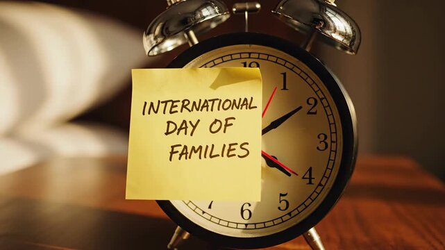 Sticky note 'International Day of Families' on classic alarm clock face