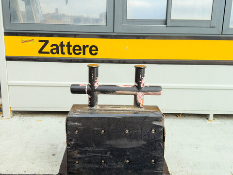 Venice, Italy - February 09, 2026: Black mooring bollard with yellow Zattere sign in Venice, Italy, showcasing urban waterfront infrastructure and maritime elements