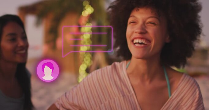 Animation of profile icon with speech bubble over two diverse female friends smiling at the beach