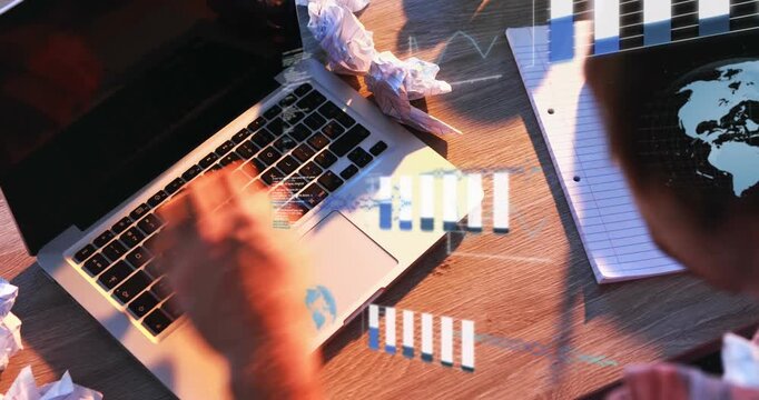 Animation of graphs, computer language and globes, overhead view of man working on laptop