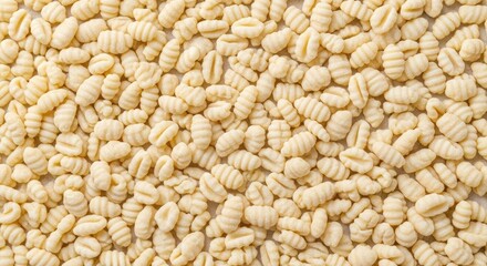 Fototapeta premium A close-up shot of a pile of fresh, uncooked gnocchi pasta. The pasta pieces are small, irregular, and have a light beige color.