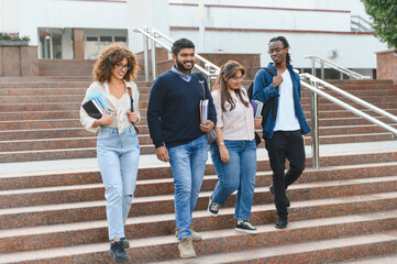 Obraz premium Diverse students walking down university campus stairs