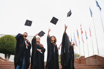 Diverse students celebrating graduation, tossing academic caps in air