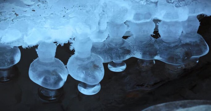 Scenes of flowing water along an outdoor riverbank in winter