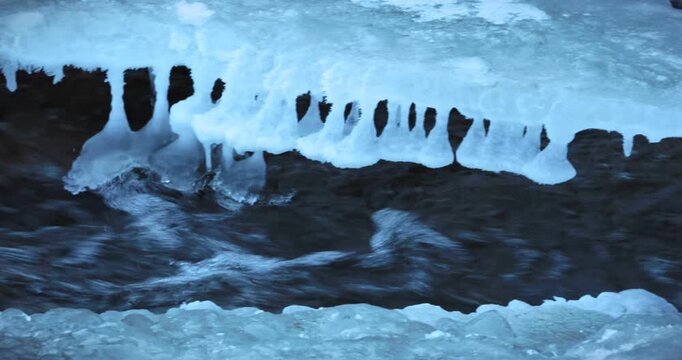 Scenes of flowing water along an outdoor riverbank in winter