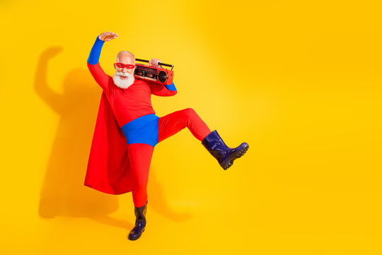 Senior superhero performer dances with a boombox on a bright yellow background for a playful halloween promotion