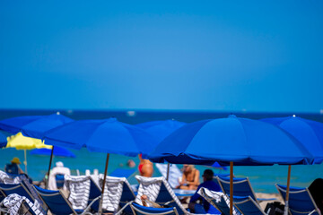Blue beach umbrellas with ocean and sky background