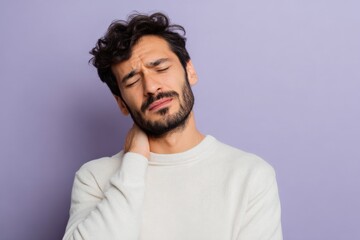Obraz premium Adult caucasian male experiencing neck pain and stiffness rubbing neck with closed eyes against lavender background