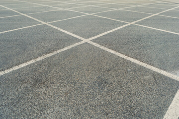 Fototapeta premium Empty parking lot with marked spaces during daytime near a busy area