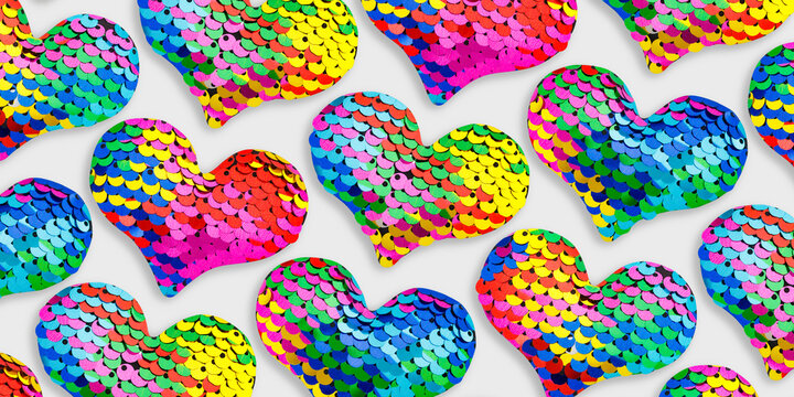 Vivid pattern from multiple heart shapes covered colorful iridescent sequins. Round sequins that create fish-scale&ndash;like shimmering texture. Love, joy, holiday creative banner, social media graphics.
