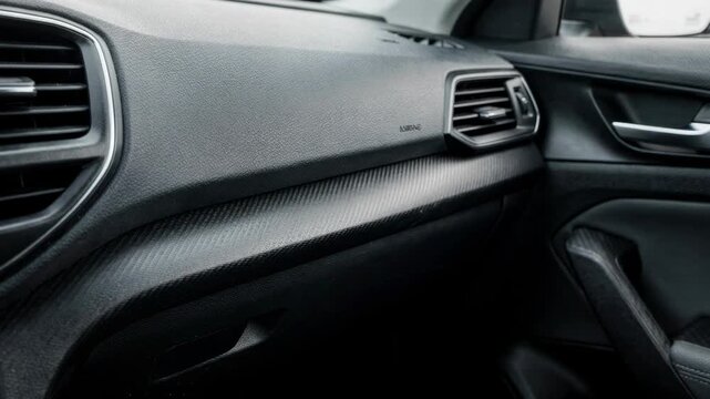 Medium shot of textured plastic automotive interior trim highlighting the intricate grain patterns on molded panels and bezels for enhanced cabin durability and style.
