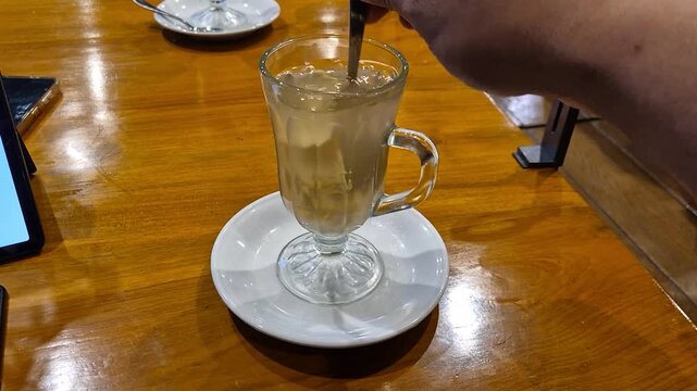a glass of Indonesian traditonal drink called "air jahe" made of crushed ginger poured with hot water