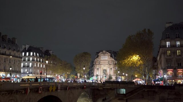 St. Michael's Bridge and Fountain at night at busy street in Paris