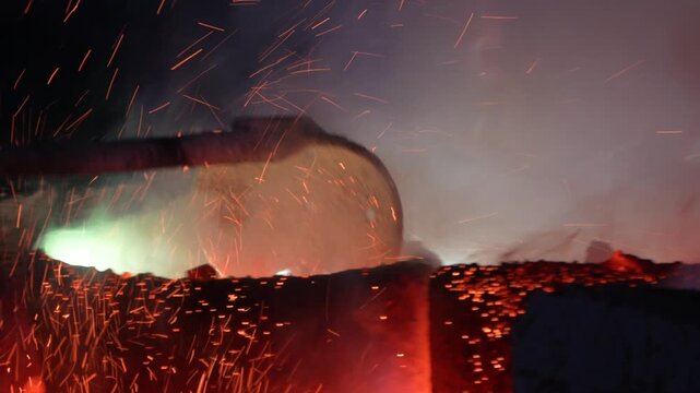 Close up of molten metal being poured into a heated crucible during casting showing intense heat, flame, and thermal energy.