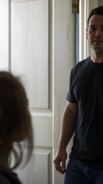 Vertical video: Holding backpack straps, girl looking up as dad entering home doorway, saying bye