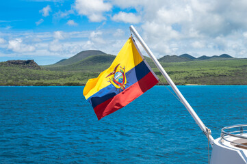 National Flag of Ecuador on Flagpole of Cruise Ship in the Galapagos Islands in Front of Mountain Background