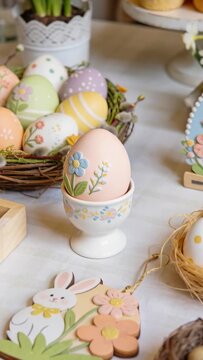 Vertical video: Panning camera focusing on peach egg in egg cup, showing rabbit tag, for spring